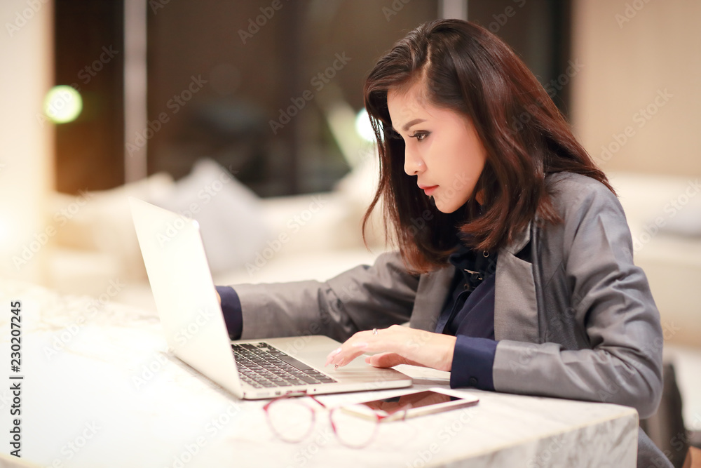 working and charming woman with glasses using laptop computer and cell phone (work from home concept) working and charming woman with glasses using laptop computer and cell phone (work from home concept)