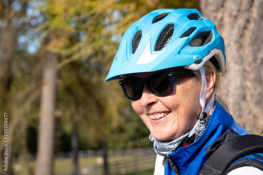 Lächelnde Frau mittleren Alters mit Fahrradhelm Lächelnde Frau mittleren Alters mit Fahrradhelm