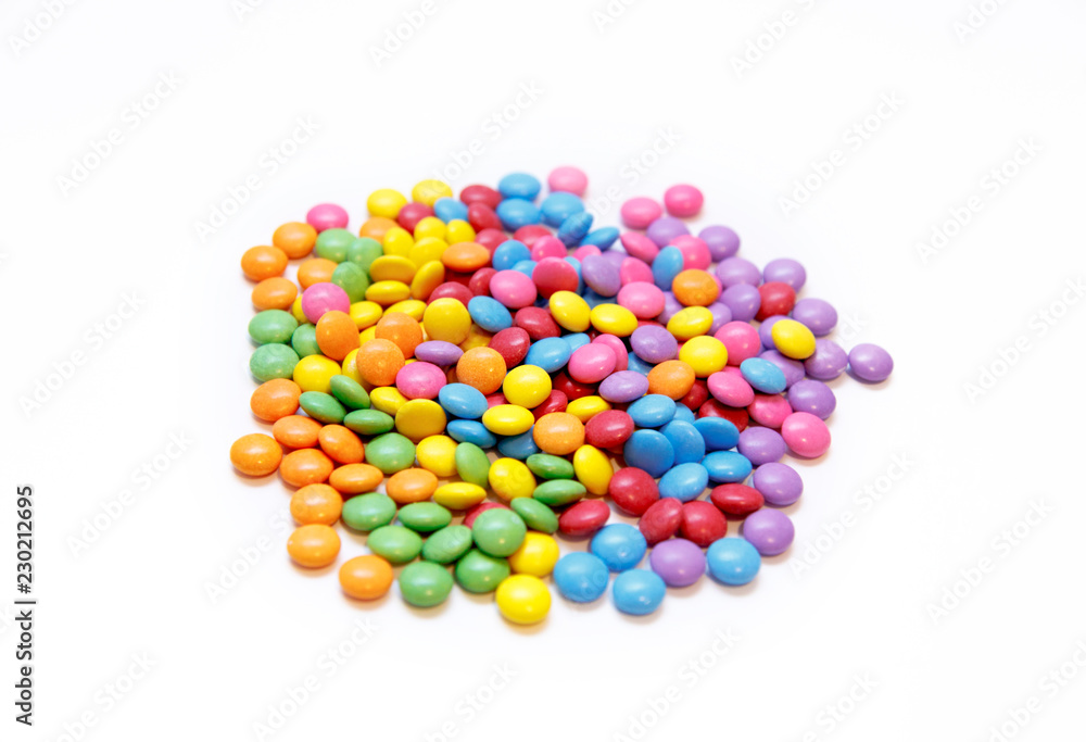 Bright chocolate dragee in a multicolored glaze on white Bright chocolate dragee in a multicolored glaze on white