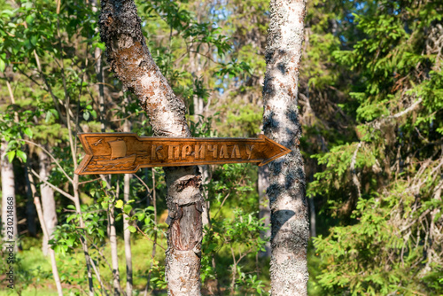 ISLAND ANZERSKY, RUSSIA - JUNE 26, 2018: Roadside forest signpost - direction of travel to the pier on Anzersky Island, Arkhangelsk Region, Russia photo