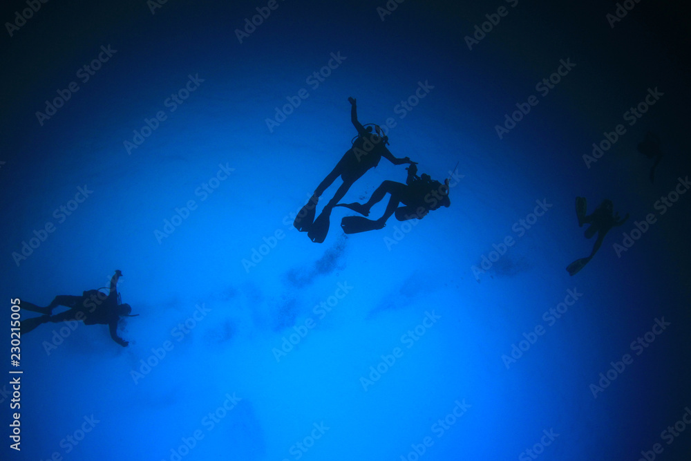 Scuba divers underwater on coral reef 