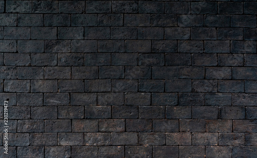 Black and brown brick wall rough texture background with space for text. Background for death, sad, hopeless and despair concept. Dark brick wall for grieving emotional. Exterior architecture.