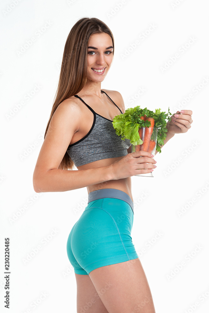 Smiling slender girl holds a blender in her hands with vegetables and herbs. Healthy nutrition, vegetable diet. Smiling slender girl holds a blender in her hands with vegetables and herbs. Healthy nutrition, vegetable diet.