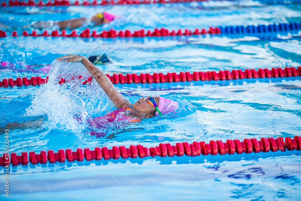 Athlete kid swimming in backstroke competition