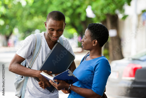 two young students standing outdoors and discussing after school, Concept of Education