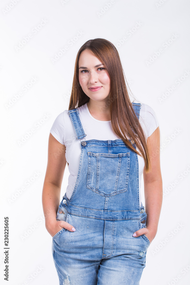 Portrait of a smiling pretty woman in denim overall isolated on white background Portrait of a smiling pretty woman in denim overall isolated on white background