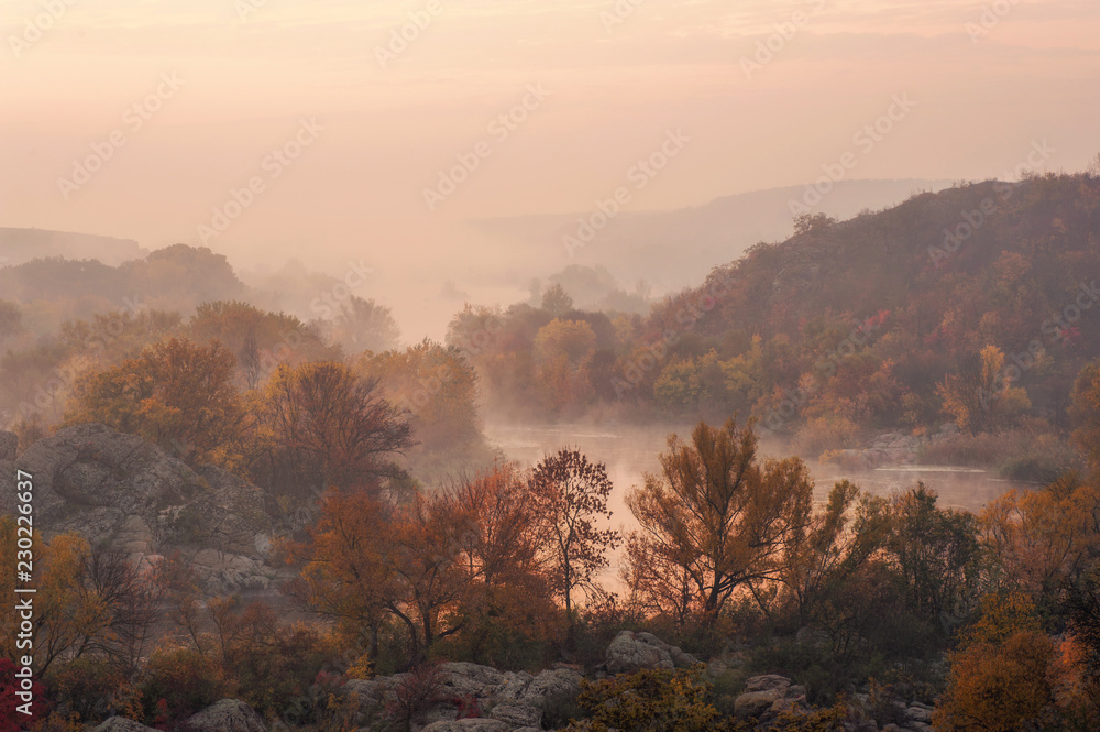 amazing aerial view of mountain rocks, blue foggy river and colorful forest on sunrise. autumn landscape