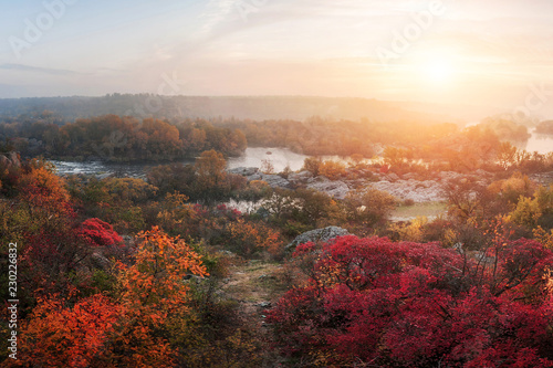 amazing aerial view of mountain rocks, foggy river and colorful forest on sunrise. autumn landscape