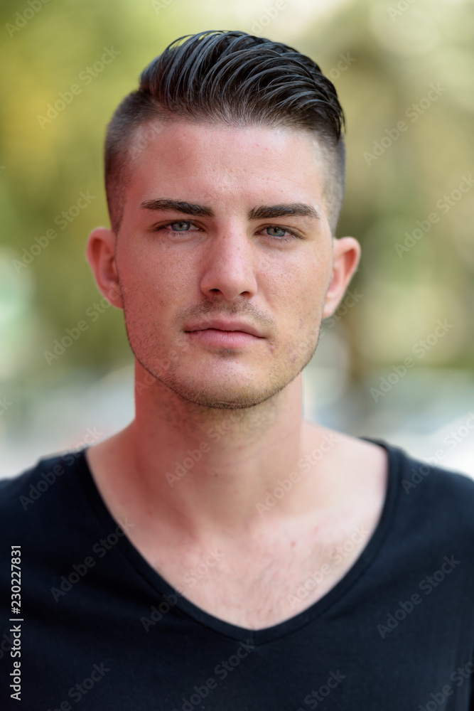 Face of young handsome man outdoors looking at camera Face of young handsome man outdoors looking at camera