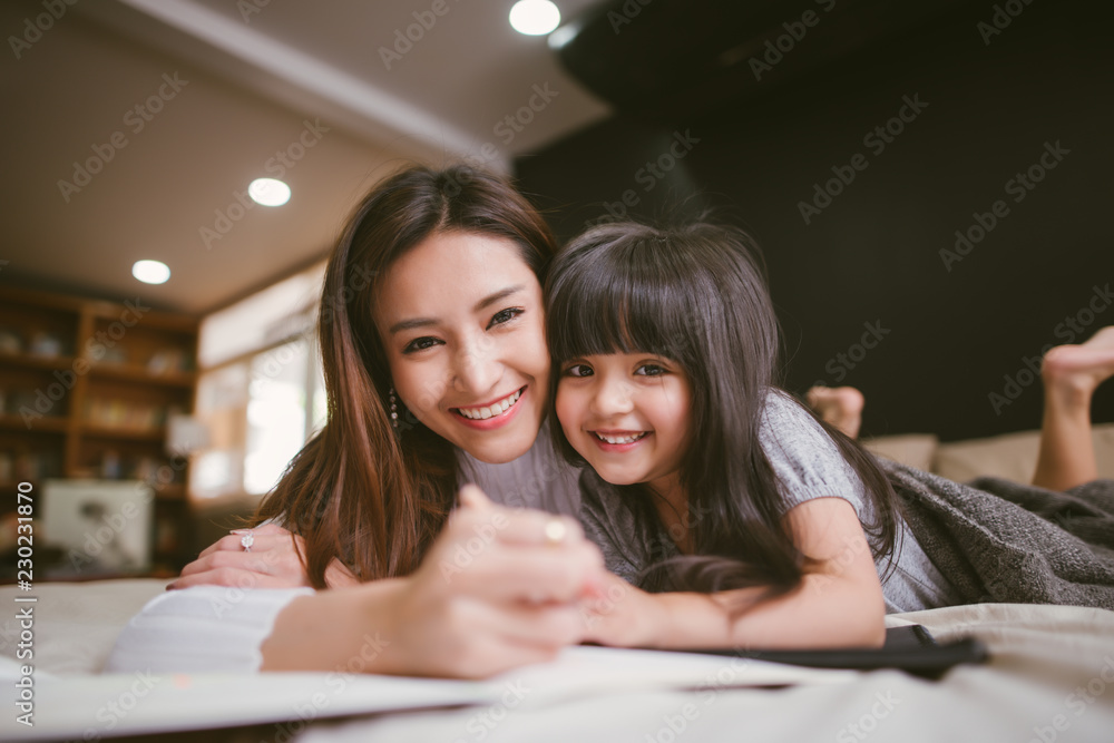 Portrait of mother and daughter playing and writing at home in the bedroom Portrait of mother and daughter playing and writing at home in the bedroom