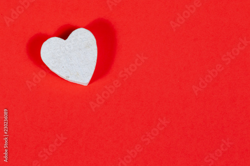 White wooden heart on red background