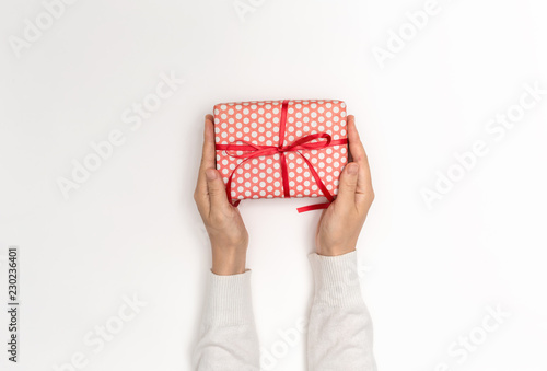 Person holding a Christmas gift box on a white background © Tierney