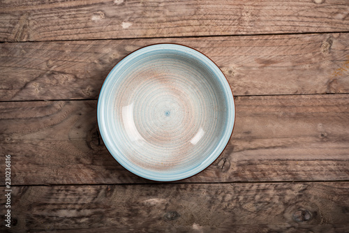 Empty dish on wood background. Top view.