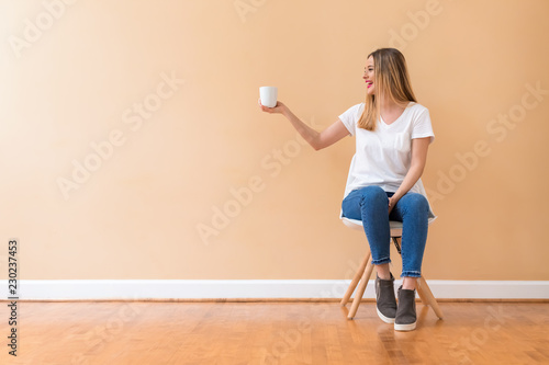 Young woman drinking a cup of coffee in a chair