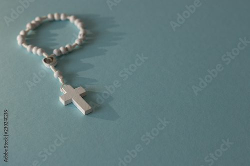 white rosary on blue background