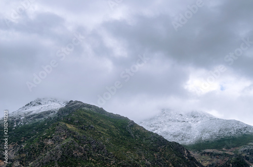 Snow on top of mountain with fog and clouds