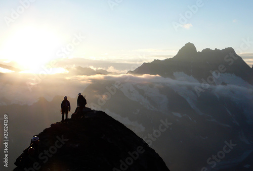several mountain climbers on the famous Mittellegi Ridge on Eiger mountain in the Alps of Switzerkland heading to the summit at sunrise © makasana photo