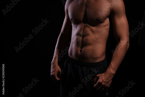 The human with muscular torso on black background,show fit and firm body,strong muscle