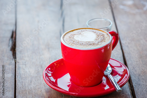 Heart latte art hot coffee on the wooden table as love concept