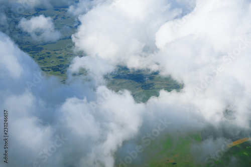 Landscape, the surface of the earth through the clouds from an airplane window.