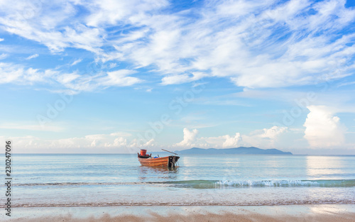 beautiful beach in morning sunrise and cloudy blue sky with fisherman boat