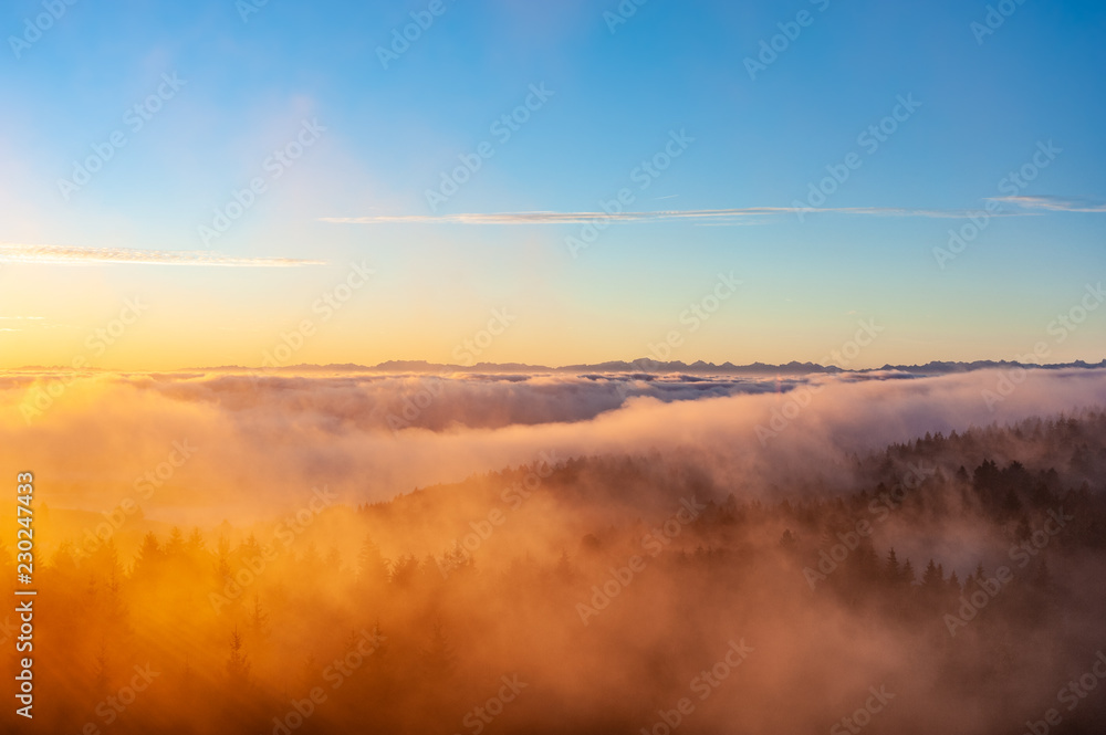Der Morgennebel bricht sich an den Hängen des Berges