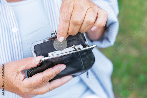 hands of an elderly woman holding a purse with money, pension