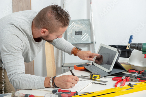 young man using a tablet to tinker at home