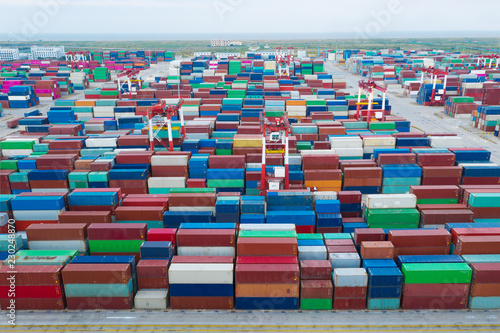 Container ship in export and import business and logistics. Shipping cargo to harbor by crane. Water transport International. Aerial view