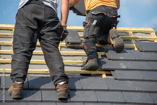 two carpenters working on roof