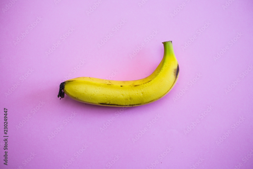 close up of a banana on pink background
