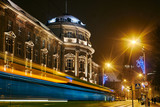 Street in front of the Medical University in Poznań at night.