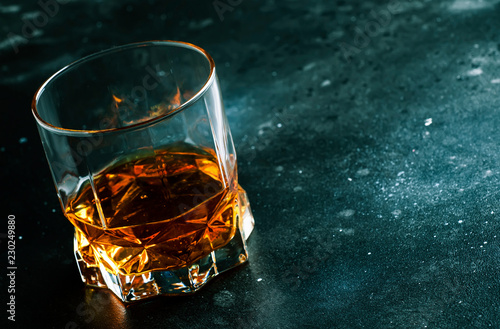 Bourbon in glass, american corn whiskey, dark bar counter, selective focus photo
