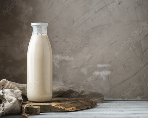 Fényképezés Fresh milk in glass bottle on rustic background