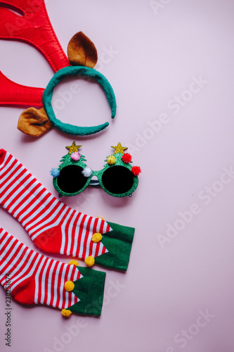 christmas background. minimalistic flat lay top view of reindeer antlers, fun glasses and elf socks. perfect for a festive merry xmas greeting card. enough room for copy space and text.