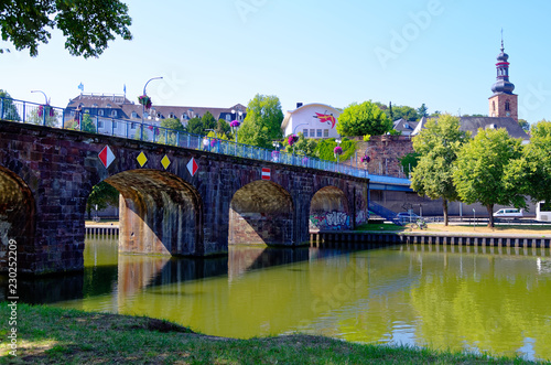 Old bridge in german Alte Brücke in Saarbrücken with the Saarbrücken castle in the background with the Saar
