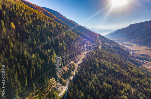 Aerial view of power line pylon in mountaineous area in Switzerland through valley in Canton of Valais photo