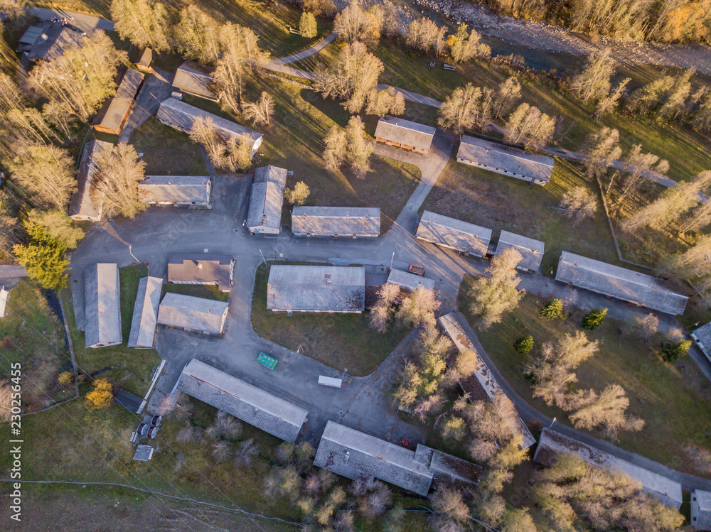Aerial view of abandoned army baracks. Rooftop in rural area with many buildings along street in Switzerland