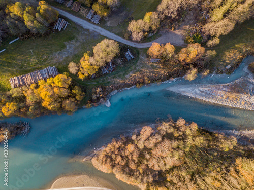 Aerial view of river in evening sunlight in Switzerland with sandbank and yellow trees