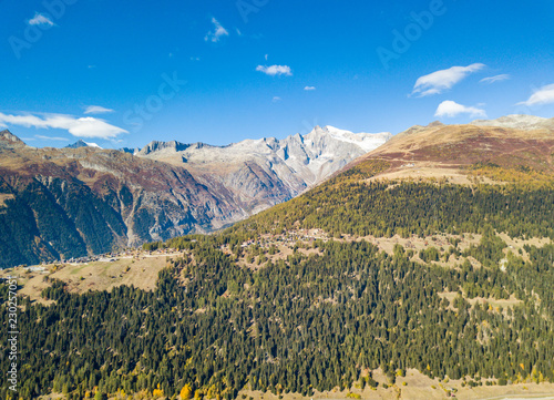 Aerial view of mountain valley in Switzerland in Canton of valais in autumn with blue sky © Mario