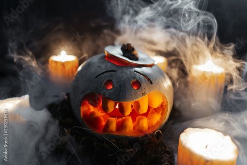 Carved Halloween pumpkin on dark background with enlighted candles. photo