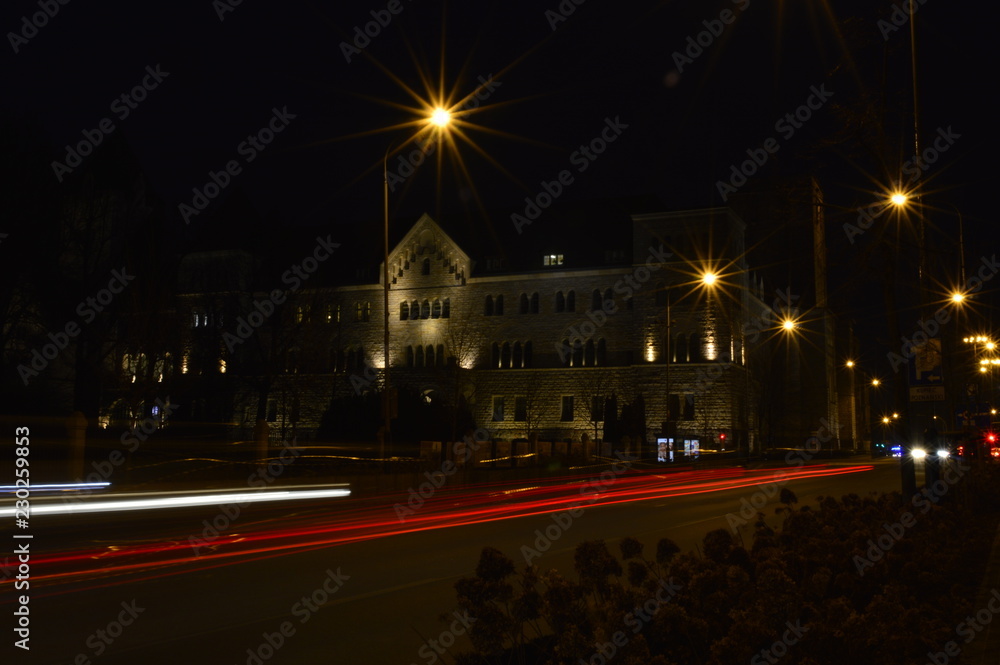 View of Imperial Castle facade in Poznan (Poland) at evening with beautiful dark blue sky background with blurred city lights