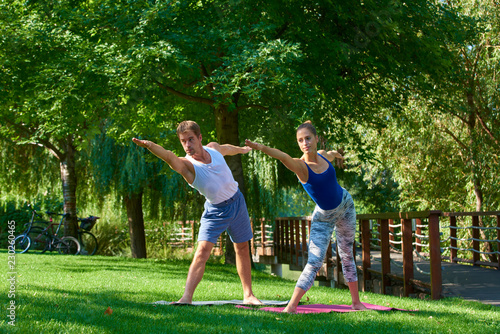 Couple doing yoga exercises together outdoor