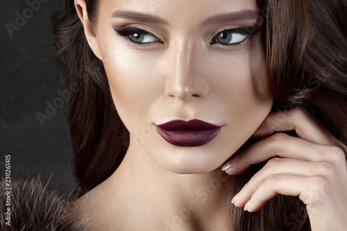 Luxurious young woman with perfect make-up with purple lipstick photo