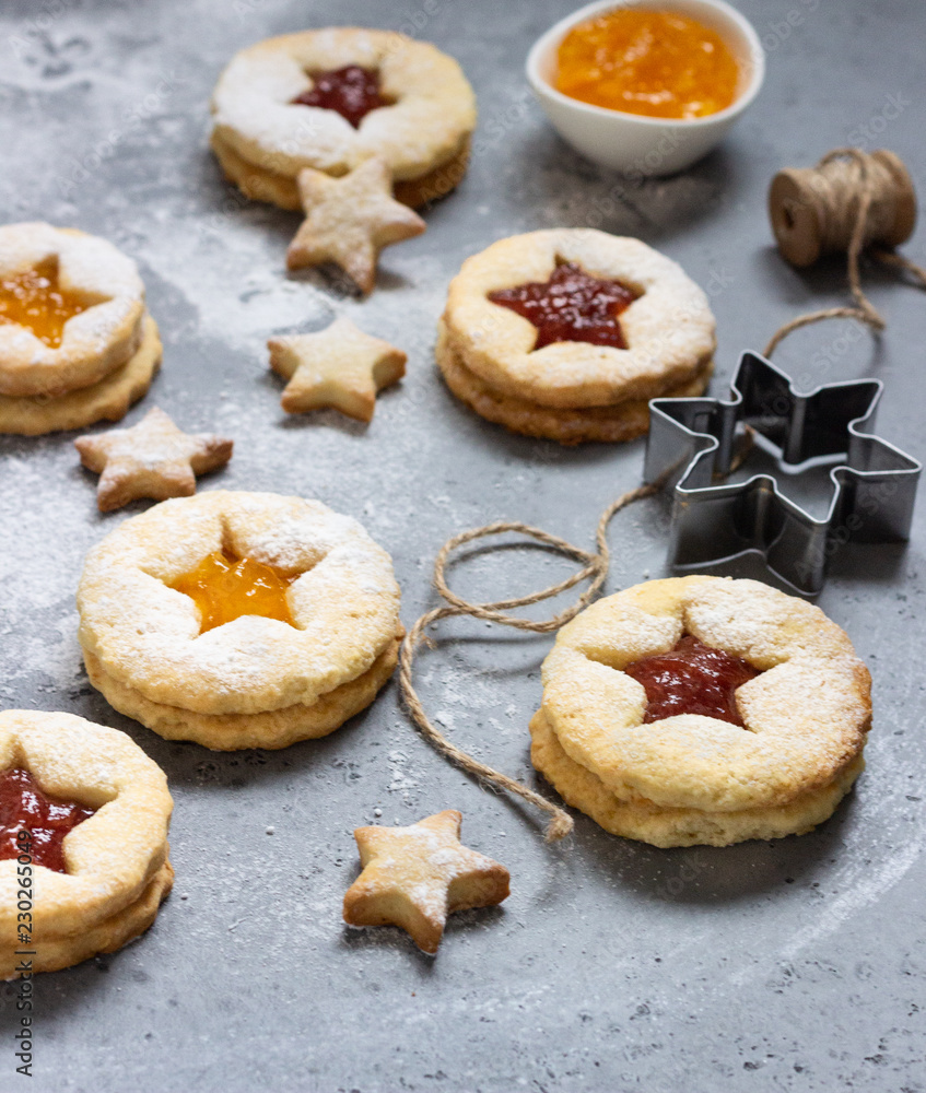 Christmas or New Year homemade cookies with red and orange jam. Flat lay. Traditional Austrian Christmas cookies - Linzer biscuits filled with jam. Top view. Copy space.