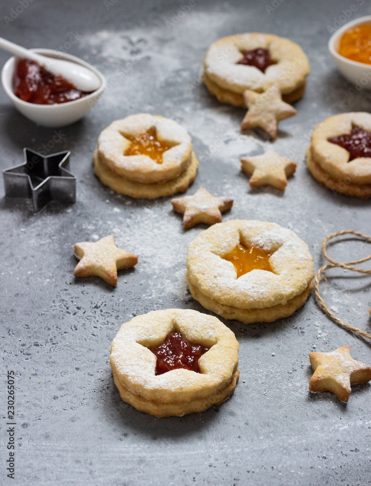 Christmas or New Year homemade cookies with red and orange jam. Flat lay. Traditional Austrian Christmas cookies - Linzer biscuits filled with jam. Top view. Copy space.