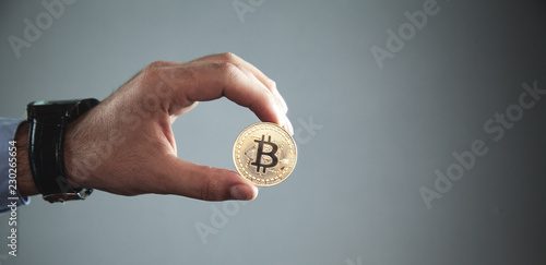 Male hand holding golden bitcoin. Virtual money concept