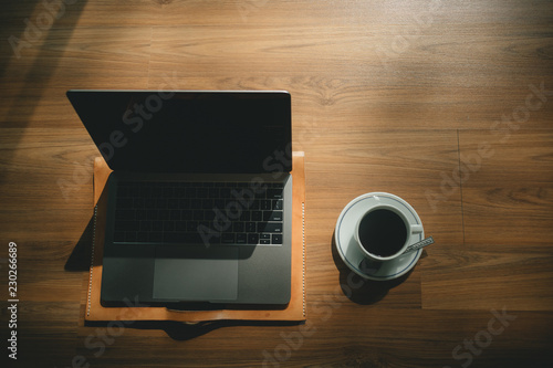 Laptop and coffee cup on wooden floor