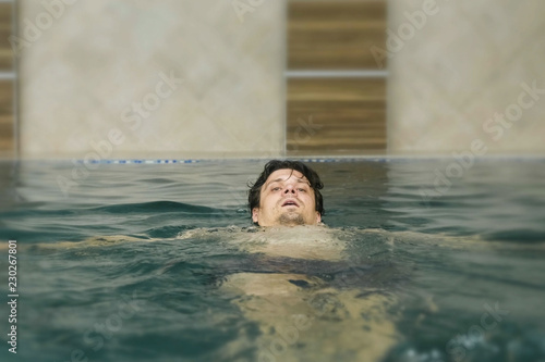 Young man is swimming in the swimming pool.