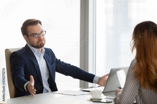 Quadro em tela Not sure businessman at meeting with partners shrugs his shoulders in doubt